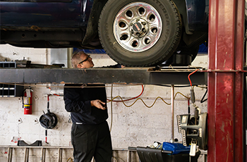 Technician working on a lifted car